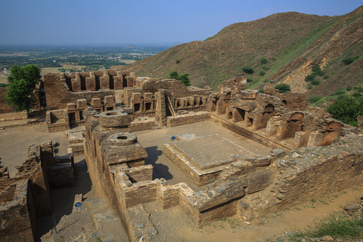 View of the ancient Buddhist monastic complex of Takht Bhai featuring stone walls and ruins set against a mountainous landscape in Takht Bhai Khyber Pakhtunkhwa Pakistan.