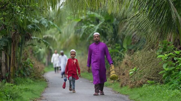 View of people walking on a path through palm trees Bangladesh. View of people walking on a path through palm trees Bangladesh.