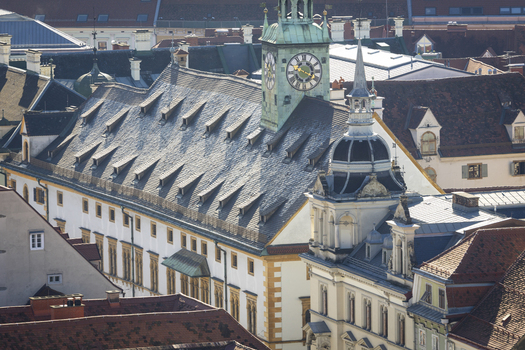 View of the historic Rathaus and Zeughaus building with its distinctive clock tower and dormer windows stands majestically amidst the urban landscape Graz Styria Austria. View of the historic Rathaus and Zeughaus building with its distinctive clock tower and dormer windows stands majestically amidst the urban landscape Graz Styria Austria.