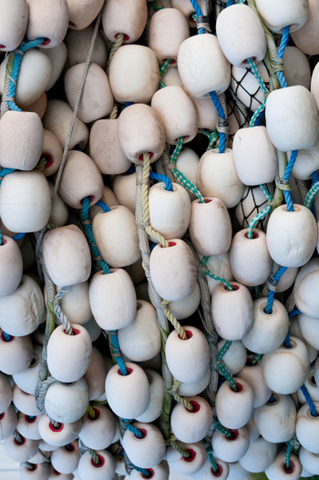View of white fishing net floats attached to blue and white ropes in Canada. View of white fishing net floats attached to blue and white ropes in Canada.