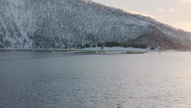 View of fish farms and snow covered mountains Norway.