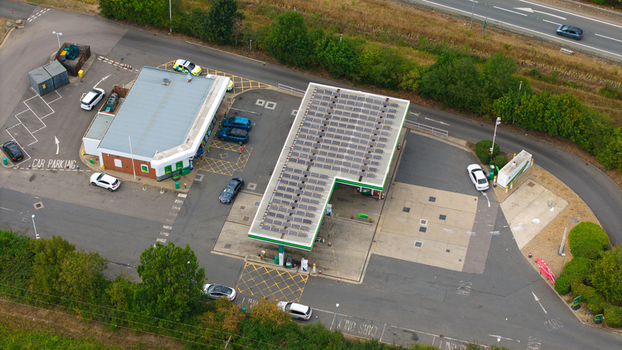 Aerial view of a gas station with solar panels on the roof and several cars parked in the forecourt in Bedford England United Kingdom.