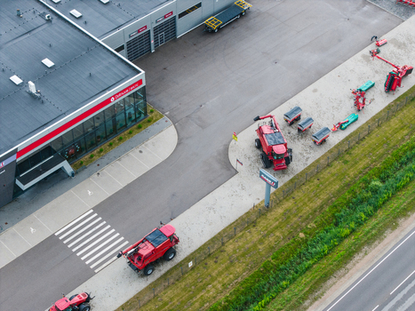 Brankas Latvia 04 July 2026 Aerial view of a modern agricultural machinery sales and service center featuring red combine harvesters parked in the lot. Brankas Latvia 04 July 2026 Aerial view of a modern agricultural machinery sales and service center featuring red combine harvesters parked in the lot.