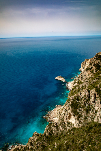 Aerial view of the rugged rocky coastline and turquoise waters of the Ionian Sea along the cliffs of Corfu Ionian Islands Greece. Aerial view of the rugged rocky coastline and turquoise waters of the Ionian Sea along the cliffs of Corfu Ionian Islands Greece.