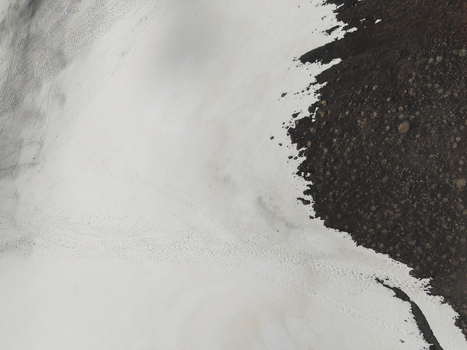 Aerial view of the southern slope of Mount Etna showing the contrast between white snow and dark volcanic rock with footprints in Nicolosi Sicilia Italy. Aerial view of the southern slope of Mount Etna showing the contrast between white snow and dark volcanic rock with footprints in Nicolosi Sicilia Italy.