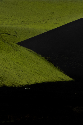 View of vibrant green fields meeting dark imposing shadows creating a striking contrast in the Icelandic landscape Skaftárhreppur Iceland. View of vibrant green fields meeting dark imposing shadows creating a striking contrast in the Icelandic landscape Skaftárhreppur Iceland.