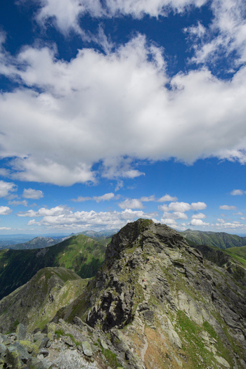 View of Tri kopy in Western Tatras with its rocky ridge and hikers on the trail under a cloudy blue sky Ziar Zilina Region Slovakia. View of Tri kopy in Western Tatras with its rocky ridge and hikers on the trail under a cloudy blue sky Ziar Zilina Region Slovakia.