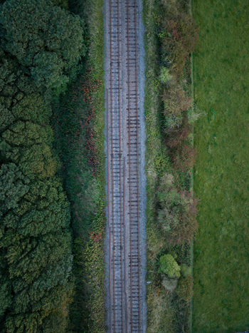 Aerial view of railway tracks cutting through the lush green landscape of the Yorkshire Dales in Leyburn England United Kingdom.