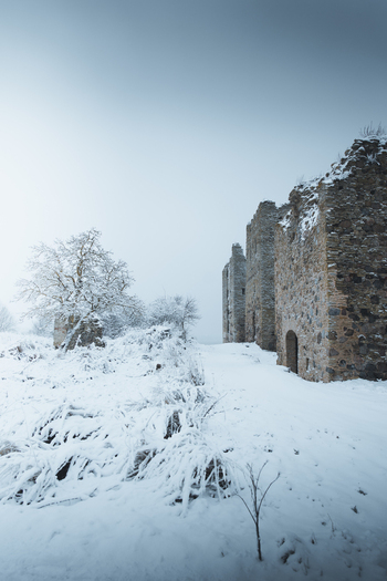 View of the historic stone ruins of Toolse fortress covered in snow during a cold winter day in Toolse Laane Viru County Estonia. View of the historic stone ruins of Toolse fortress covered in snow during a cold winter day in Toolse Laane Viru County Estonia.