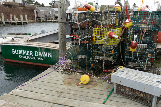 Edgartown United States 14 May 2026 View of lobster traps and colorful buoys stacked on a wooden pier next to a fishing boat in the harbor of Martha s Vineyard.