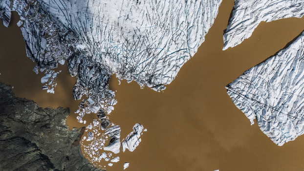 Aerial view of jagged ice formations meet the muddy waters in a stark contrast creating an ethereal landscape Hoffellsjokull Iceland. Aerial view of jagged ice formations meet the muddy waters in a stark contrast creating an ethereal landscape Hoffellsjokull Iceland.