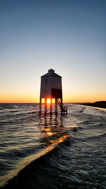 Aerial view of the Burnham on Sea Low Lighthouse standing in the sea at sunset with gentle waves and a golden horizon in Burnham on Sea England United Kingdom. Aerial view of the Burnham on Sea Low Lighthouse standing in the sea at sunset with gentle waves and a golden horizon in Burnham on Sea England United Kingdom.