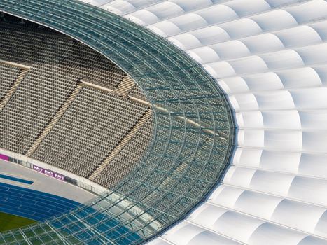 Berlin Germany 26 September 2026 Aerial view of Olympiastadion Berlin showing the iconic glass roof structure curved seating tiers and the blue athletic track below.