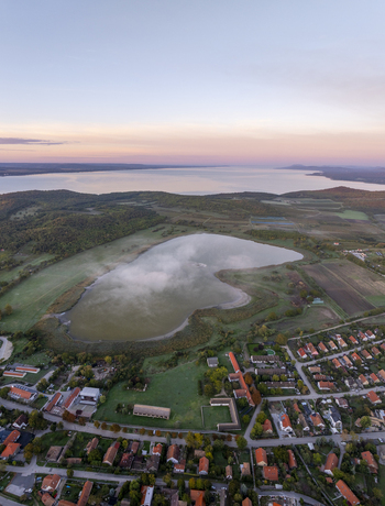 Aerial view of Tihany Abbey overlooking the mist covered Inner Lake and the vast expanse of Lake Balaton at sunrise in Tihany Hungary. Aerial view of Tihany Abbey overlooking the mist covered Inner Lake and the vast expanse of Lake Balaton at sunrise in Tihany Hungary.