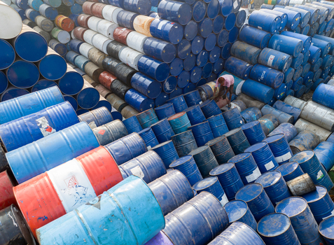 Aerial view of thousands of stacked colorful industrial barrels with a worker standing among them in Dhaka Dhaka Division Bangladesh. Aerial view of thousands of stacked colorful industrial barrels with a worker standing among them in Dhaka Dhaka Division Bangladesh.
