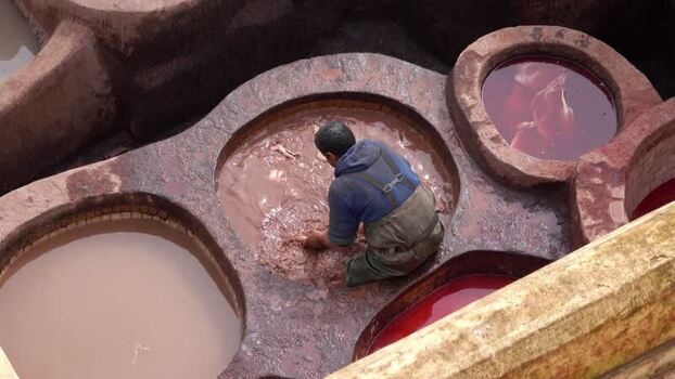 View of a worker at the historic Chouara Tannery in Fes Morocco.