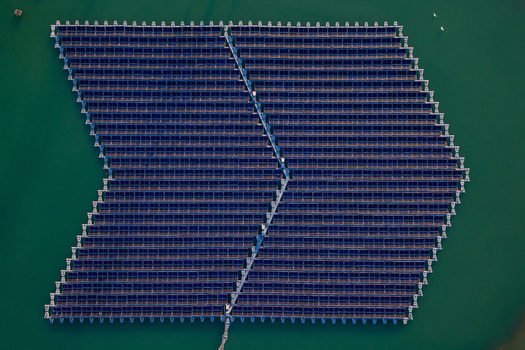 Aerial view of floating solar farm with blue panels on green water in Bensheim Hessen Germany. Aerial view of floating solar farm with blue panels on green water in Bensheim Hessen Germany.