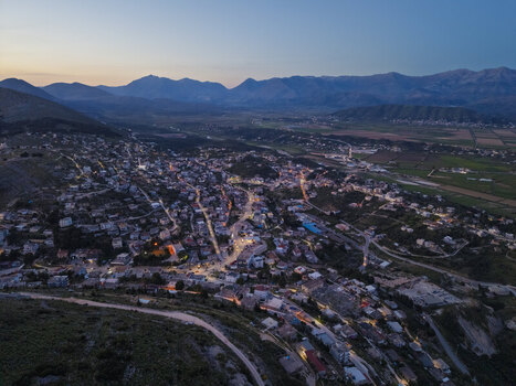Aerial view of the coastal town of Saranda illuminated at twilight with mountains in the background Saranda Vlore County Albania. Aerial view of the coastal town of Saranda illuminated at twilight with mountains in the background Saranda Vlore County Albania.