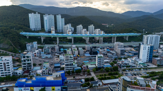 Aerial view of Songjeong dong featuring a prominent elevated highway bridge modern apartment complexes and surrounding mountains in Busan Busan South Korea. Aerial view of Songjeong dong featuring a prominent elevated highway bridge modern apartment complexes and surrounding mountains in Busan Busan South Korea.