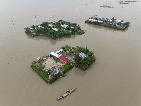 Mithamain Bangladesh 10 September 2025 Aerial view of small island settlements with tin roofed houses and green trees surrounded by floodwaters and a wooden boat. Mithamain Bangladesh 10 September 2025 Aerial view of small island settlements with tin roofed houses and green trees surrounded by floodwaters and a wooden boat.