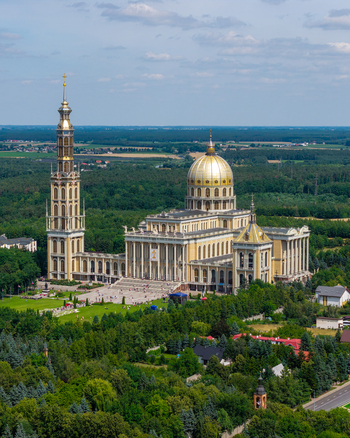 Aerial view of the Basilica of Our Lady of Lichen with its golden dome and tall bell tower surrounded by lush green trees and parkland in Lichen Stary Wielkopolskie Poland. Aerial view of the Basilica of Our Lady of Lichen with its golden dome and tall bell tower surrounded by lush green trees and parkland in Lichen Stary Wielkopolskie Poland.