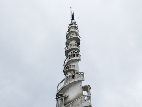 Aerial view of the white spiral Ambuluwawa Tower with people on its balconies under an overcast sky in Gampola Central Province Sri Lanka. Aerial view of the white spiral Ambuluwawa Tower with people on its balconies under an overcast sky in Gampola Central Province Sri Lanka.