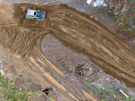 Aerial view of a skid steer loader working on a muddy construction site with deep tire tracks in Istanbul Istanbul Turkiye. Aerial view of a skid steer loader working on a muddy construction site with deep tire tracks in Istanbul Istanbul Turkiye.