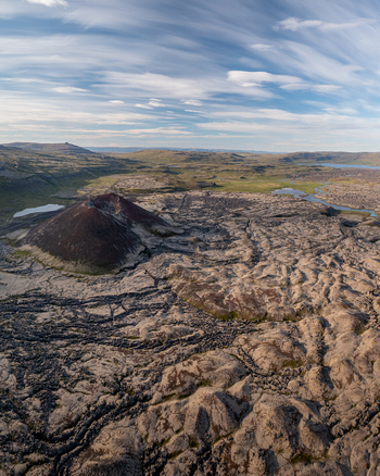 Aerial view of Ytri Raudarmelskula volcanic crater surrounded by vast lava fields and rugged terrain under a blue sky in Raudhamelur Eyja og Miklaholtshreppur Iceland. Aerial view of Ytri Raudarmelskula volcanic crater surrounded by vast lava fields and rugged terrain under a blue sky in Raudhamelur Eyja og Miklaholtshreppur Iceland.