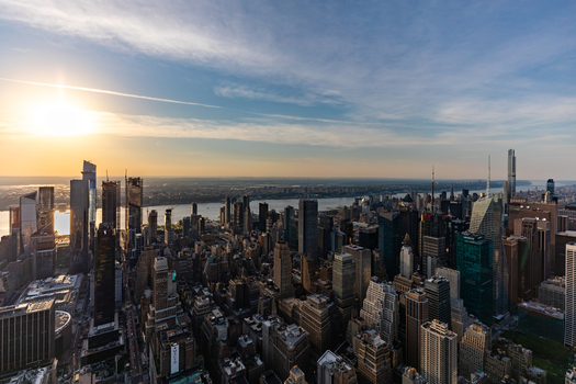 View of the New York City skyline at sunset with skyscrapers the Hudson River and golden light reflecting off the buildings in New York New York United States. View of the New York City skyline at sunset with skyscrapers the Hudson River and golden light reflecting off the buildings in New York New York United States.