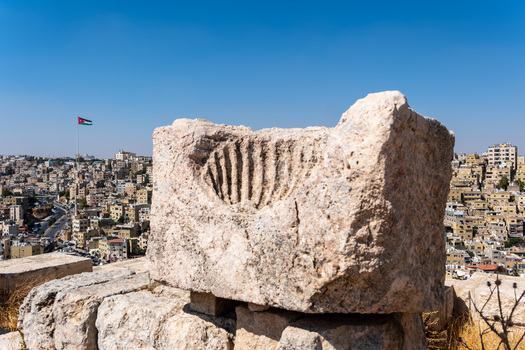 View of the ancient carved stone block at the Umayyad Palace with the cityscape of Amman in the background Amman Amman Governorate Jordan.