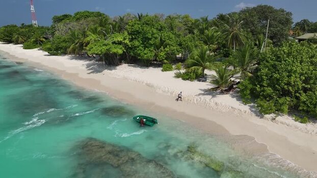 Aerial view of a tropical beach with a boat and palm trees Maldives. Aerial view of a tropical beach with a boat and palm trees Maldives.