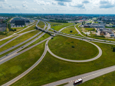 Aerial view of a multi level highway interchange with green grassy areas and vehicles driving on the roads in Kaunas Kaunas County Lithuania.