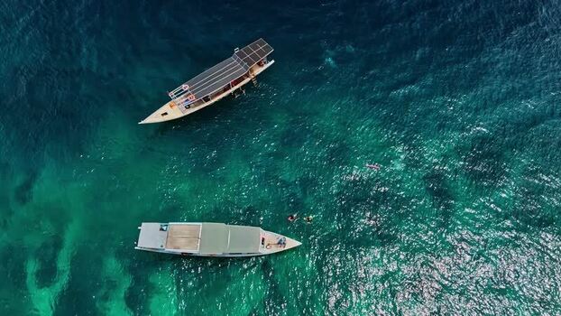 Aerial view of boats in turquoise water Indonesia.