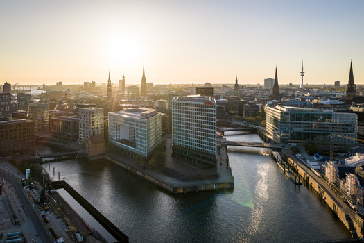 Hamburg Germany 22 April 2026 Aerial view of the Spiegel Building and modern architecture along the Ericusspitze canal with city spires and the setting sun in the background.