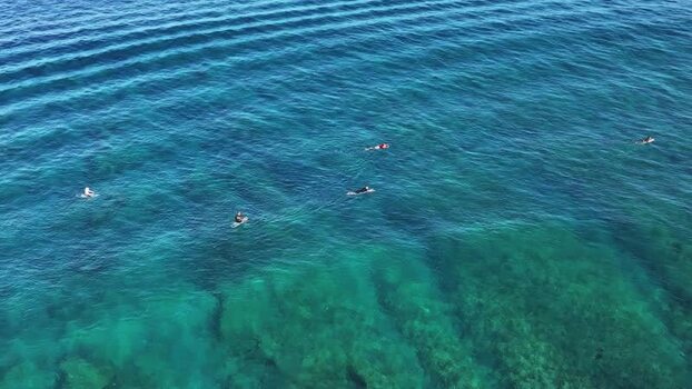 Aerial view of surfers in turquoise water in Thulusdhoo Maldives.