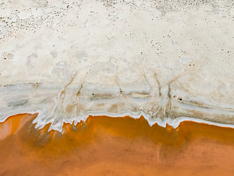 Aerial view of the abstract patterns of a salt lake in the Mallee region with vibrant orange water and white salt crusts Woorinen North Victoria Australia. Aerial view of the abstract patterns of a salt lake in the Mallee region with vibrant orange water and white salt crusts Woorinen North Victoria Australia.