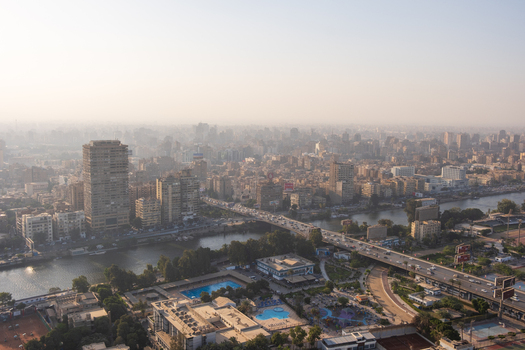 View of a sprawling cityscape bathed in golden sunlight bridges arching over the shimmering river and buildings piercing the skyline Zamalek Cairo Governorate Egypt. View of a sprawling cityscape bathed in golden sunlight bridges arching over the shimmering river and buildings piercing the skyline Zamalek Cairo Governorate Egypt.