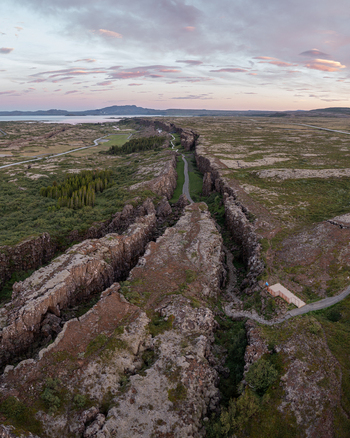 Aerial view of Thingvellir National Park showing the Almannagja gorge rugged volcanic rock formations and winding paths through the mossy landscape in Selfoss Blaskogabyggd Iceland. Aerial view of Thingvellir National Park showing the Almannagja gorge rugged volcanic rock formations and winding paths through the mossy landscape in Selfoss Blaskogabyggd Iceland.