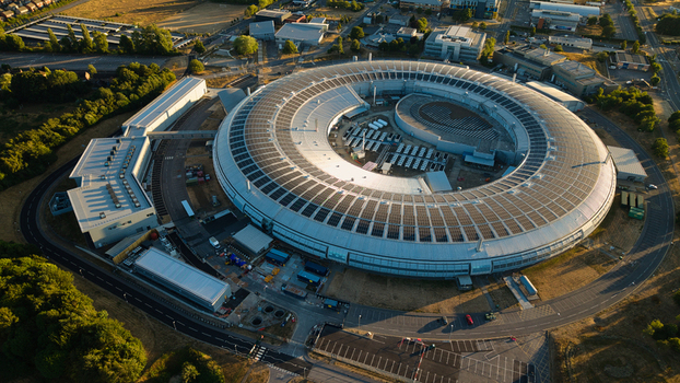 Aerial view of Diamond Light Source a circular synchrotron facility surrounded by greenery under golden hour light in Didcot United Kingdom.