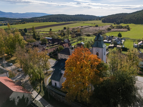 Aerial view of a village church and vivid autumn foliage against green landscapes Klastor pod Znievom Zilina Region Slovakia. Aerial view of a village church and vivid autumn foliage against green landscapes Klastor pod Znievom Zilina Region Slovakia.