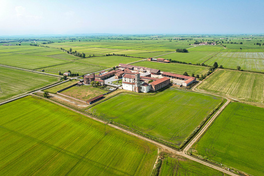 Aerial view of the historic Abbazia di Lucedio surrounded by vast green rice fields in the rural landscape of Trino Piemonte Italy. Aerial view of the historic Abbazia di Lucedio surrounded by vast green rice fields in the rural landscape of Trino Piemonte Italy.