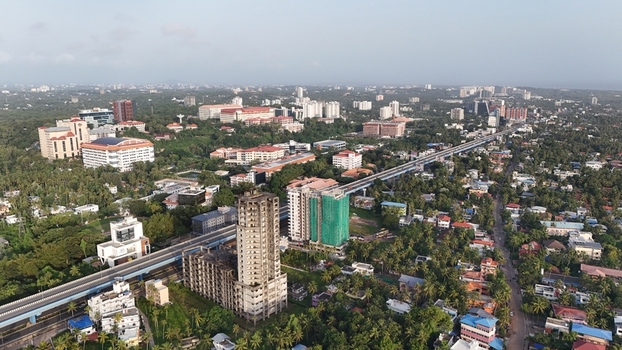 Aerial view of the Kazhakuttam area featuring a prominent highway modern high rise buildings construction sites and dense tropical vegetation in Thiruvananthapuram Kerala India. Aerial view of the Kazhakuttam area featuring a prominent highway modern high rise buildings construction sites and dense tropical vegetation in Thiruvananthapuram Kerala India.