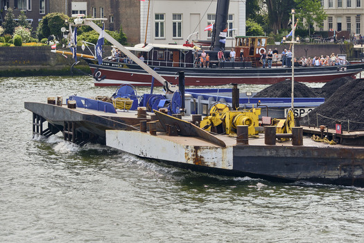 Dordrecht South Holland Netherlands 31 May 2026 View of a cargo barge carrying coal navigating the Oude Maas river with a passenger boat in the background.