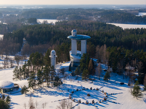 Aerial view of the Lithuanian Museum of Ethnocosmology with its futuristic tower domes and a stone circle in a snowy forest in Kulionys Utenos apskritis Lithuania.