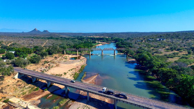 Aerial view of the Olifants River flowing through the savanna landscape with a bridge and a truck driving across in Hoedspruit Limpopo South Africa. Aerial view of the Olifants River flowing through the savanna landscape with a bridge and a truck driving across in Hoedspruit Limpopo South Africa.