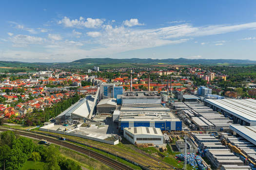Aerial view of an industrial manufacturing facility with large warehouses and production buildings situated near a railway line and the town of Kyjov South Moravian Region Czechia.