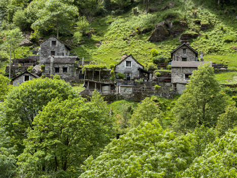 Aerial view of Corippo Albergo Diffuso featuring traditional stone houses nestled on a lush green hillside in Corippo Ticino Switzerland. Aerial view of Corippo Albergo Diffuso featuring traditional stone houses nestled on a lush green hillside in Corippo Ticino Switzerland.