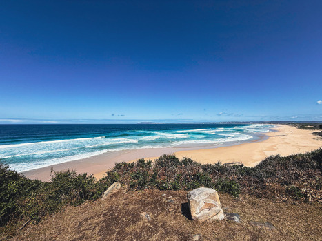 View of the expansive sandy beach and turquoise ocean waves from a coastal lookout in Plettenberg Bay Western Cape South Africa. View of the expansive sandy beach and turquoise ocean waves from a coastal lookout in Plettenberg Bay Western Cape South Africa.