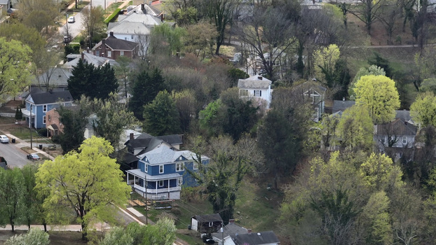 Aerial view of Rivermont Avenue in spring with historic houses nestled among lush trees and blooming foliage in a quiet residential neighborhood in Lynchburg Virginia United States.