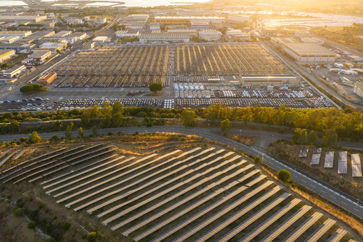 Aerial view of the automotive terminal at Civitavecchia Port with rows of parked vehicles industrial warehouses and a large solar panel array in Civitavecchia Lazio Italy. Aerial view of the automotive terminal at Civitavecchia Port with rows of parked vehicles industrial warehouses and a large solar panel array in Civitavecchia Lazio Italy.